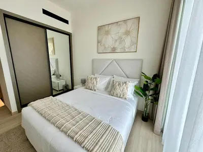 a bedroom with a large white bed with pillows at Cozy Elegant 1br Balcony, Pool Access, Parking in Dubai