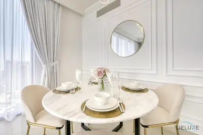 a white dining room with a white table and chairs at Luxurious 2BR Apartment at Boulevard Point Downtown Dubai by Deluxe Holiday Homes in Dubai