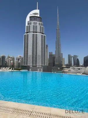 a large swimming pool in front of a city skyline at Luxurious 2BR Apartment at Boulevard Point Downtown Dubai by Deluxe Holiday Homes in Dubai