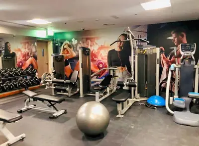a gym with several tread machines and a mural at Downtown Studio near Dubai Mall in Dubai