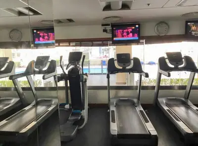 a gym with several treadmills and televisions at Downtown Studio near Dubai Mall in Dubai