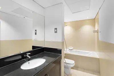 a bathroom with a sink and a toilet and a mirror at Downtown Studio near Dubai Mall in Dubai