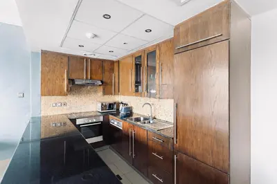 a kitchen with wooden cabinets and a sink at Downtown Studio near Dubai Mall in Dubai