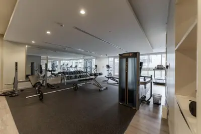 a gym with tread machines and a mirror at Contemporary Apartment with Burj Khalifa View in Dubai