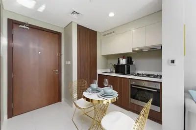 a kitchen with a table and chairs and a door at Contemporary Apartment with Burj Khalifa View in Dubai