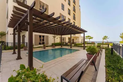 a swimming pool with a pergola next to a building at Beach stylish full sea view in Dubai
