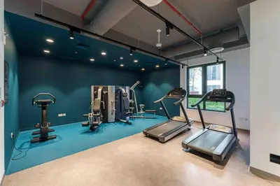 a gym with cardio equipment in a room with blue walls at Beach stylish full sea view in Dubai