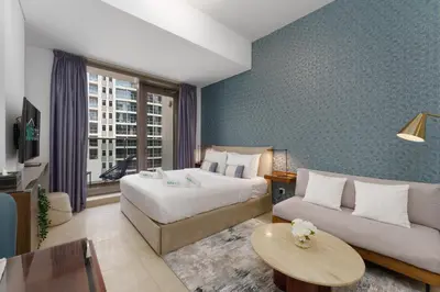 a hotel room with a bed and a couch at Elevated Living studio in Sparkle Tower- Suiteable in Dubai