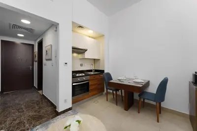 a kitchen and dining room with a table and chairs at Elevated Living studio in Sparkle Tower- Suiteable in Dubai