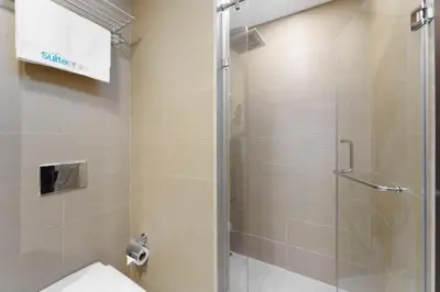 a bathroom with a glass shower with a toilet at Elevated Living studio in Sparkle Tower- Suiteable in Dubai