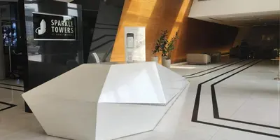 a white bench in a building with a sign on it at Elevated Living studio in Sparkle Tower- Suiteable in Dubai