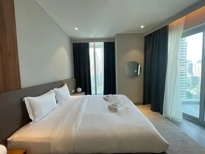 a bedroom with a large white bed with a large window at Dubai Marina Walk Gem Modern Apartments with Pool & Gym access, Steps to Beach & Metro Managed by SunnyHomes in Dubai