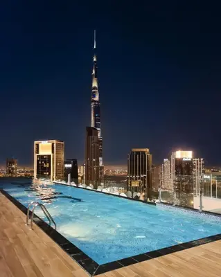 a swimming pool on the roof of a building with a city skyline at Best Burj Khalifa View Balcony Apartment with 64th-Floor Infinity Pool in Paramount Hotel Midtown in Dubai