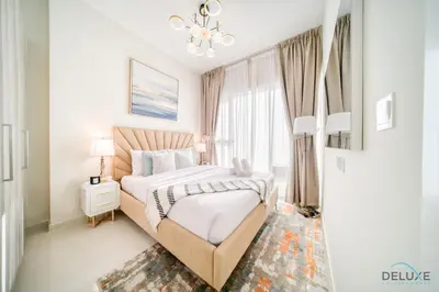 a bedroom with a bed and a chandelier at Peaceful 1BR at Golf Vita A Damac Hills by Deluxe Holiday Homes in Dubai