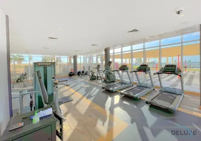 a gym with a lot of treadmills and ellipticals at Peaceful 1BR at Golf Vita A Damac Hills by Deluxe Holiday Homes in Dubai