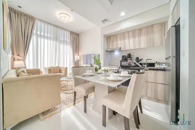 a kitchen and living room with a table and chairs at Peaceful 1BR at Golf Vita A Damac Hills by Deluxe Holiday Homes in Dubai