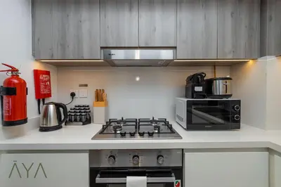 a kitchen with a stove and a microwave at Stylish 2BR Apartment at Dubai Hills with Pool Access By ĀYA Boutique in Dubai