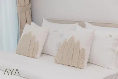 a group of white pillows on a bed at Stylish 2BR Apartment at Dubai Hills with Pool Access By ĀYA Boutique in Dubai