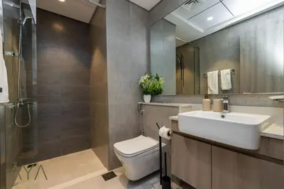 a bathroom with a toilet and a sink and a mirror at Stylish 2BR Apartment at Dubai Hills with Pool Access By ĀYA Boutique in Dubai