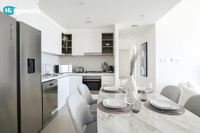 a kitchen and dining room with a table and chairs at HiGuests - Sky-High Luxury 2BR Apt in Downtown Views Dubai in Dubai