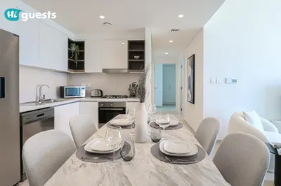 a kitchen and dining room with a table and chairs at HiGuests - Sky-High Luxury 2BR Apt in Downtown Views Dubai in Dubai