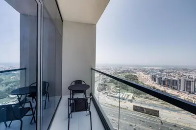 a room with a balcony with tables and chairs at A Living - Luxury Studio Apartment in Aykon City Canal Views, Business bay in Dubai