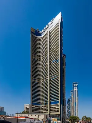 a tall building with a sign on the side of it at A Living - Luxury Studio Apartment in Aykon City Canal Views, Business bay in Dubai