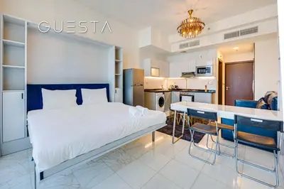 a bedroom with a large bed and a kitchen at Bayz Tower, Business Bay in Dubai