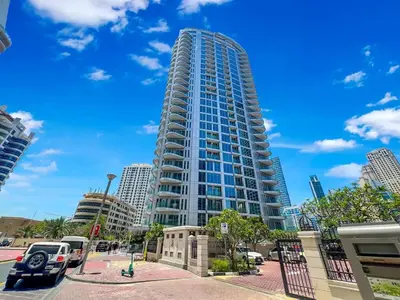 a tall building with cars parked in front of it at FAM Living - Stunning Modern Marina Apartment in Dubai