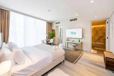 a bedroom with a large bed and a flat screen tv at FAM Living - Stunning Modern Marina Apartment in Dubai