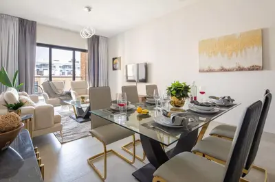 a dining room and living room with a table and chairs at Frank Porter - Eleganz 5 in Dubai
