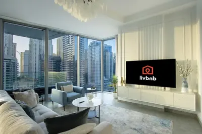 a living room with a couch and a tv at Deluxe 1BR Corner Suite with Marina Views in Dubai