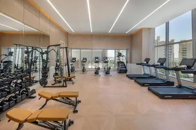 a gym with treadmills and cardio equipment in a building at Palm Tower Luxury 1BR Sea View Suites with 5 Star Hotel Amenities in Dubai