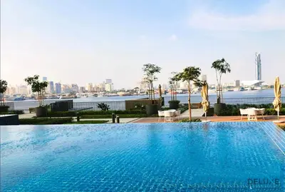 a large swimming pool with a view of the city at Charming 1BR Apartment in Creek Edge Tower 1, Dubai Creek Harbor by Deluxe Holiday Homes in Dubai