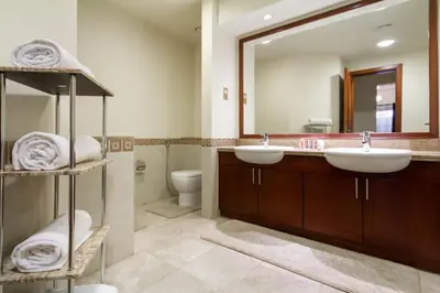 a bathroom with two sinks and a large mirror at Bespoke Holiday Homes - Palm Jumeirah- 1 Bedroom North Residence in Dubai