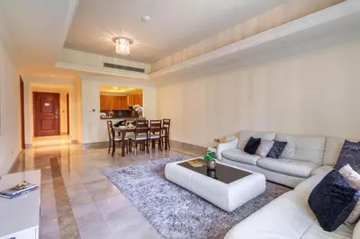 a living room with a white couch and a table at Bespoke Holiday Homes - Palm Jumeirah- 1 Bedroom North Residence in Dubai