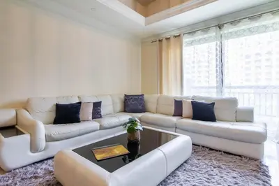 a living room with a white couch and a table at Bespoke Holiday Homes - Palm Jumeirah- 1 Bedroom North Residence in Dubai