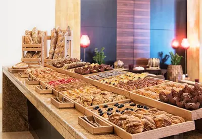 a bakery with many different types of pastries on display at Bespoke Holiday Homes - Palm Jumeirah- 1 Bedroom North Residence in Dubai