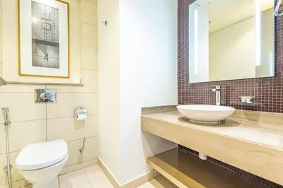 a bathroom with a sink and a toilet and a mirror at Dubai Dreaming Stylish 1BR, DAMAC Towers Paramount in Dubai