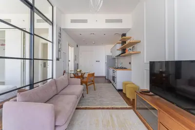 a living room with a couch and a tv at HAVN - 1 Bedroom in Collective, Dubai Hills Estate in Dubai