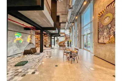 a hallway with tables and chairs in a library at HAVN - 1 Bedroom in Collective, Dubai Hills Estate in Dubai