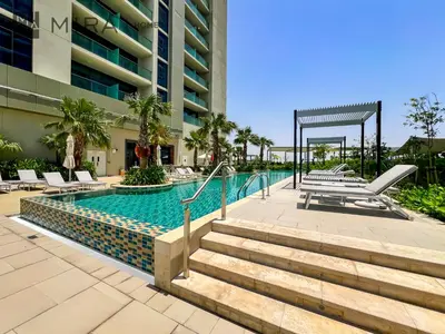 a swimming pool at a resort with lounge chairs at Mira Holiday Homes - Fully Furnished Studio in Business Bay in Dubai