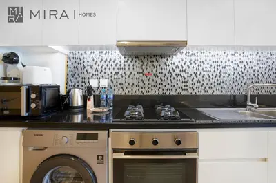 a kitchen with a stove and a washing machine at Mira Holiday Homes - Fully Furnished Studio in Business Bay in Dubai