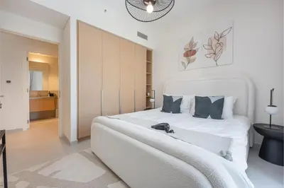 a bedroom with a large white bed with blue pillows at HAVN - 1 Bedroom in Bayshore 2, Creek Beach in Dubai