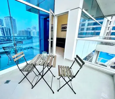 two chairs and a table on a balcony at JBR Walk Full Apartment Marina View in Dubai
