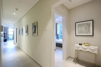 a hallway of a home with a table and paintings at 2BR in Central Marina Walk to Dining & Nightlife in Dubai
