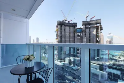 a balcony with a table and chairs looking out at the city at 2BR in Central Marina Walk to Dining & Nightlife in Dubai