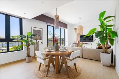 a living room with a table and chairs and a couch at Ocean View 2BR with a Pool & Gym, 2 min to Beach in Dubai