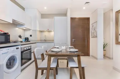 a kitchen with a wooden table and white appliances at STAY BY LATINEM Luxury 1BR Holiday Home CVR A2003 near Burj Khalifa in Dubai