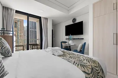 a bedroom with a large white bed and a balcony at Stonetree - GoldCrest Views 2 - Peaceful Community in Dubai